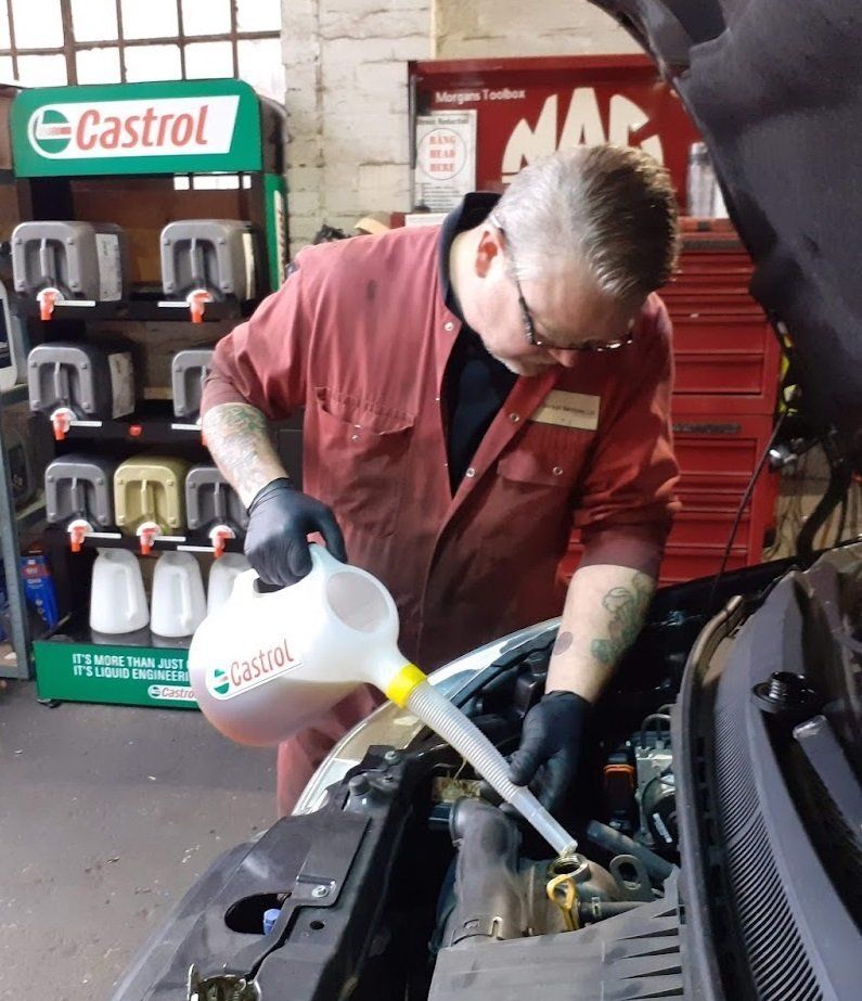 Jason topping up engine oil from a Castrol bottle
